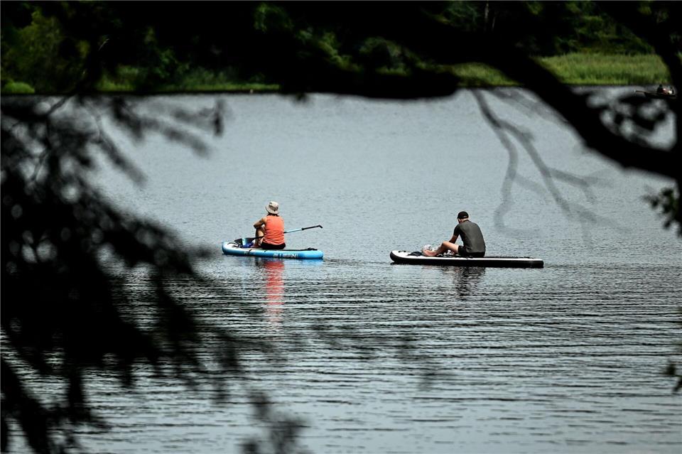 wei Stand-Up-Paddler sitzen auf dem Schlachtensee auf ihren SUP Boards.Britta Pedersen/dpa